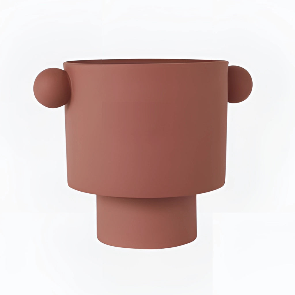 Large cinnamon-colored ceramic vase in Scandinavian design, showcasing earthy tones and a hand-molded cylindrical shape, displayed as a centerpiece on a table.