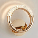 Luxurious metallic wall lamp with a rotatable angle, featuring a sleek design and circular elements resembling jewelry.