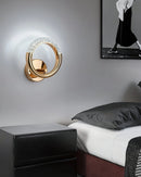 Luxurious metallic wall lamp with a rotatable angle, mounted on a grey wood-paneled wall, complementing the serene white interior design.