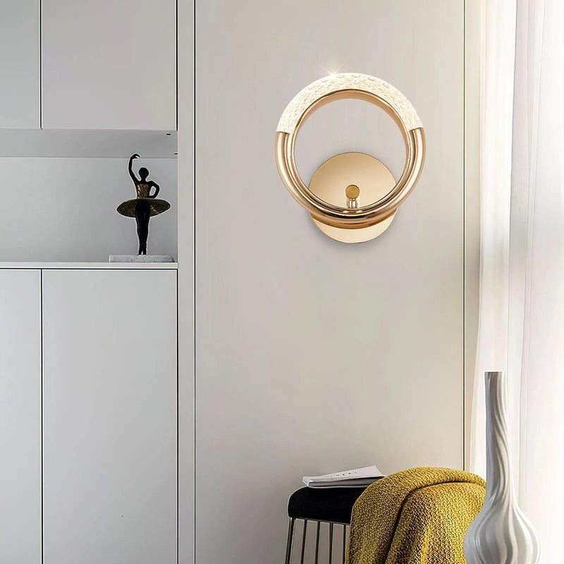 Luxurious metallic wall lamp with an adaptable angle, mounted on a white wall beside a mirror, enhancing the interior design of the room.