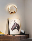 Elegant metallic wall lamp with a rotatable angle, featuring a luxurious design and set against a wooden background.