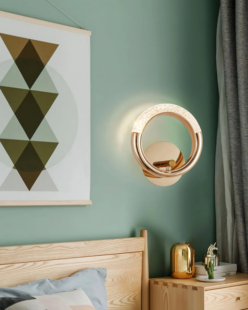 Luxurious metallic wall lamp with an adaptable angle, mounted on a cabinetry with a mirror, featuring wood and textile accents in white, green, and azure colors.