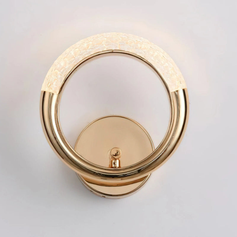 Luxurious metallic wall lamp with an adaptable angle rotatable design, featuring a circular metal base and stylish elements resembling fashion accessories.