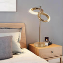 An adjustable Nordic style wall lamp with rotatable design displayed on a wooden table in an interior setting.