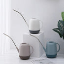 Modern and functional April Showers garden watering can surrounded by plants.