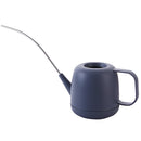 Modern and functional April Showers Garden Watering Can displayed on a table, surrounded by various kitchenware including cups and dishware, predominantly in electric blue tones.