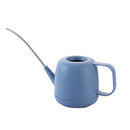 Modern and functional April Showers Garden Watering Can displayed on a table, featuring an electric blue color and made from durable plastic.