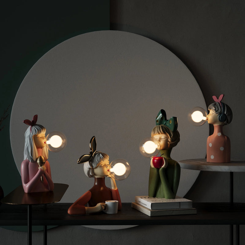 Handcrafted wooden table lamp by Artisan Sisters featuring a creative, artistic design with a carmine hue, set in a shadowy, still life photography setup.