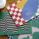 Back to the Future inspired geometric entrance doormat featuring a creative pattern of white, green, and aqua lines and shapes on a textile surface.