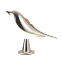 Silver bird-shaped LED lamp on a table, featuring a metallic finish and dimmable cordless design.
