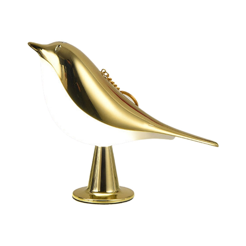 Gold bird-shaped lamp with LED light, featuring metallic finish and artistic design, displayed on a wooden nightstand.