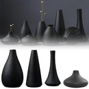 Black ceramic vase displayed with a focus on its sleek design and artistic lines, suitable for both home and garden settings.