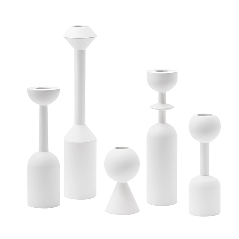 Black wooden candle holder set displayed on a table, featuring artistic still life arrangement with subtle home accessories, under a ceiling fixture.
