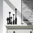 Black wooden candle holder set accompanied by a monochrome photograph of a seabird, featuring distinct black and white tones emphasizing the bird's feathers and beak.