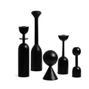 Set of five black wooden candle holders arranged in a balanced display, suitable for home decor, featuring cylindrical shapes and artistic design elements.