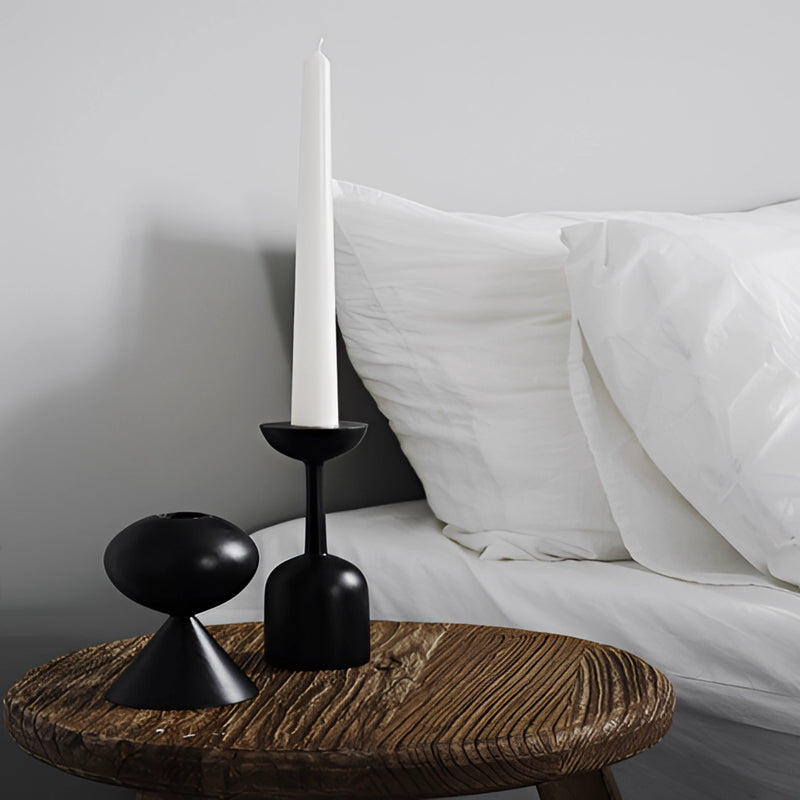 Black wooden candle holder set displayed on a hardwood floor in a grey-themed room, enhancing the home decor with its rectangular shape and artistic design.