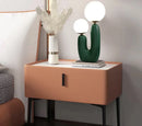 Cactus design table lamp featuring milk glass globes on a wooden base, providing LED lighting, positioned on a white rectangle table beside a chair in an interior setting.