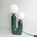 Cactus design table lamp featuring milk glass globes on a table, with artistic elements and LED innovation, ideal for modern interiors.