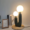 Cactus design table lamp with milk glass globes on a wooden table, featuring LED lighting and artistic rectangular frame elements.