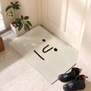Cartoon design indoor outdoor rug featuring a happy big eyes pattern, placed on a hardwood floor with houseplants in the background.