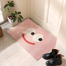 Indoor outdoor rug featuring a cartoon design with happy big eyes, displayed on a hardwood floor in a room with plants and a window, providing a vibrant and playful atmosphere.