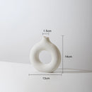 White small ceramic donut-shaped vase for modern home decor, featuring a circular and oval design, made of porcelain.