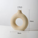 Beige medium-sized ceramic donut-shaped vase designed for modern home decor, featuring a circular form and a smooth, neutral finish.