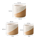 Ceramic flowerpot shaped like a coffee cup with a cylindrical design, displayed on a table.