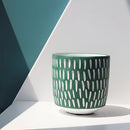 Hand-painted ceramic planters with textured designs, displayed on a table resembling dishware and drinkware settings.