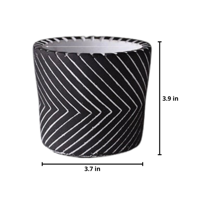 Black ceramic hand-painted planter with textured designs displayed on a surface.