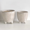 Ceramic pots with island holiday designs, displayed on a table, showcasing artistic and colorful ceramic craftsmanship.