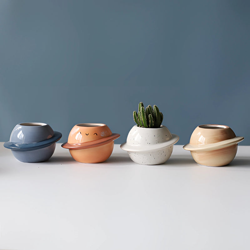 Ceramic planet-shaped plant pot with an astral galaxy design, displayed as a decorative flowerpot.
