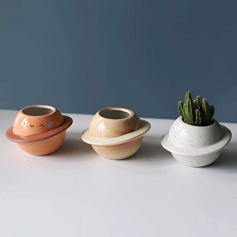 Ceramic planet-shaped plant pot with an astral galaxy design, featuring intricate pottery and creative art elements.
