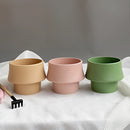 Glazed ceramic planter in rosa with a Scandinavian style, displayed on a table, featuring pottery and earthenware elements.