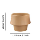 Glazed ceramic planter in rosa with a Scandinavian style, displayed on a wooden surface.