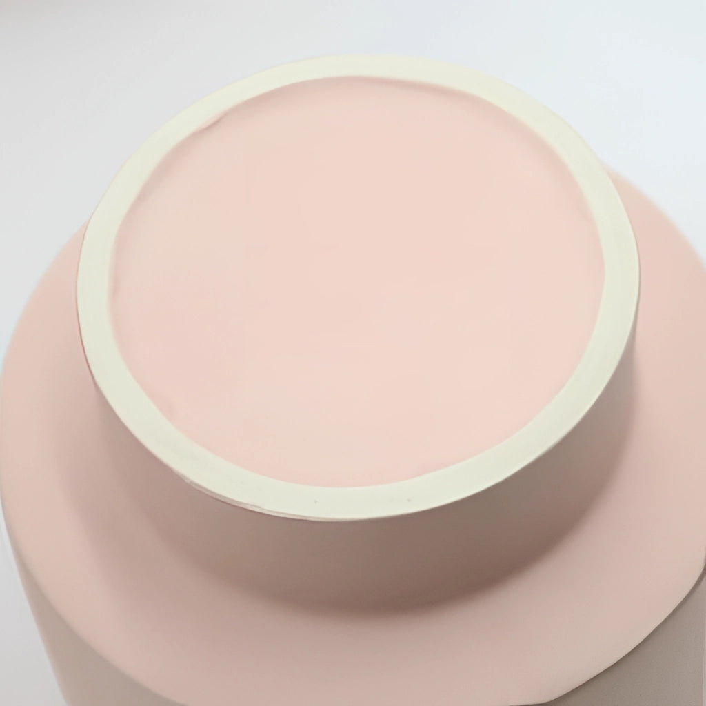 Hand molded ceramic vase in Scandinavian design featuring earthy tones of peach and magenta, with artistic pottery and bangle shapes.