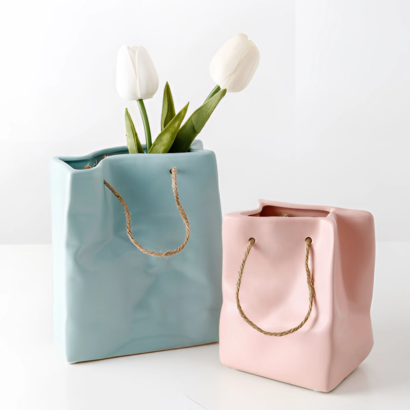 Ceramic vase designed to resemble a shopping basket, featuring elements that mimic petals and plants, used as a decorative household item.