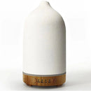 Ceramic wood grain aromatherapy diffuser with a beige cylindrical body, designed to resemble a chimney, featuring a metal and leather fashion accessory detail.