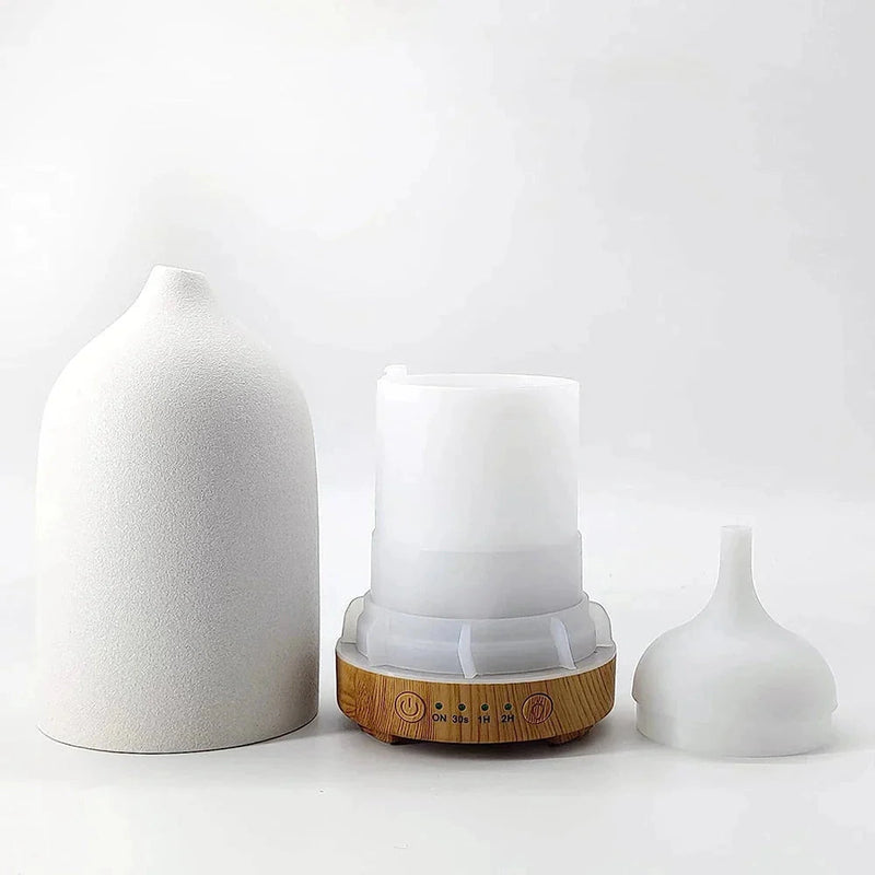 Ceramic wood grain aromatherapy diffuser with a 7-color night light, featuring a cylindrical shape and displayed in a still life setting.