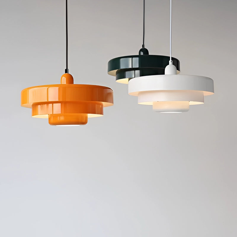 Modern metal pendant lamp featuring linked circle designs, suspended from a ceiling, with a rectangular wood backdrop enhancing tints and shades.