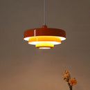 Amber-tinted pendant lamp with interlinked metal circles design, hanging from the ceiling.