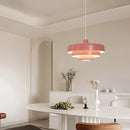 Modern linked circles pendant lamp in metal with a Rosa finish, featuring three color temperature settings, displayed above a wooden table in a stylishly designed interior.