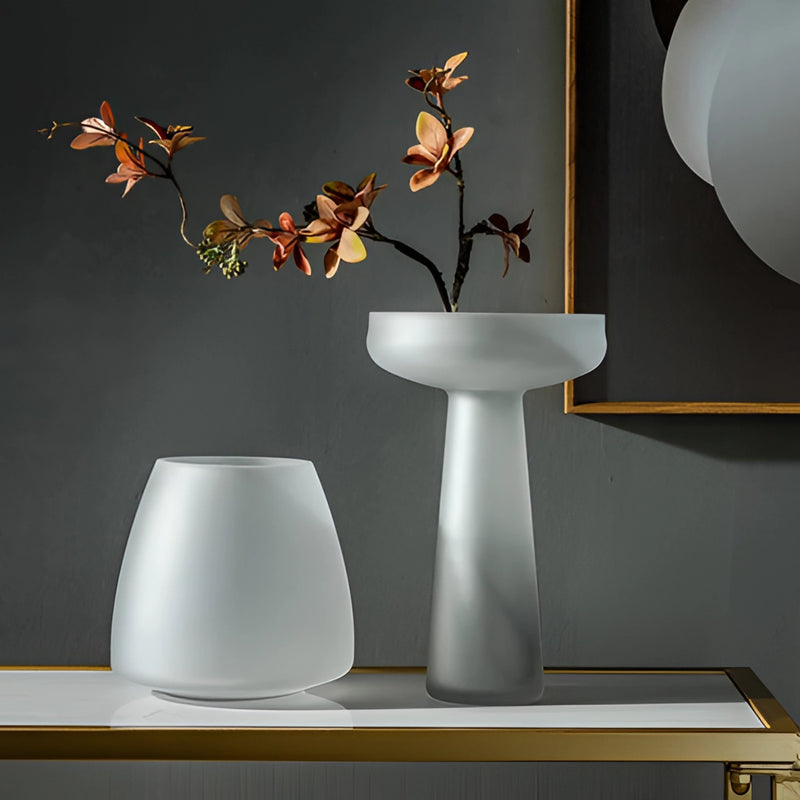 Coffee-colored frosted glass vase on a table, illuminated by soft lighting, enhancing the artistic and interior design elements in the setting.