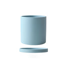 Sky blue ceramic planter with a matching saucer, displayed on a table, showcasing its cylindrical shape and vibrant electric blue color.