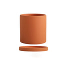 Large orange ceramic planter with a matching saucer, featuring a cylindrical shape and vibrant magenta and electric blue accents.
