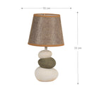 Contemporary fabric lampshade on a wooden desk with metal accents, featuring a ceiling chandelier in the background.