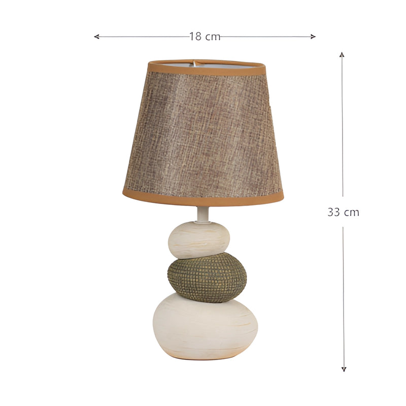 Contemporary fabric lampshade on a wooden desk with metal accents, featuring a ceiling chandelier in the background.