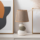 Contemporary fabric lampshade on a wooden desk, featuring a rectangular design with artistic tints and shades, enhancing the room's lighting ambiance.