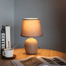 Rechargeable table lamp with a unique style, featuring a wooden base and lampshade, artfully positioned on a hardwood floor with soft lighting.