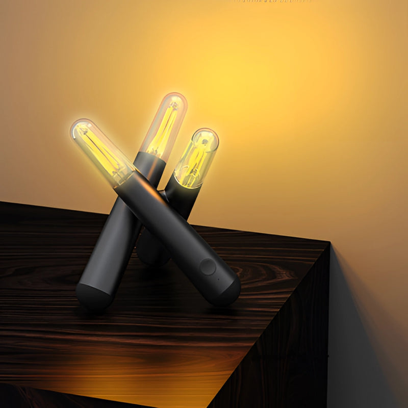 Clear cordless kinetic rotation LED table lamp on a wooden table.